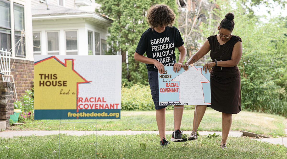 a family putting up a yard sign about racial covenant removal